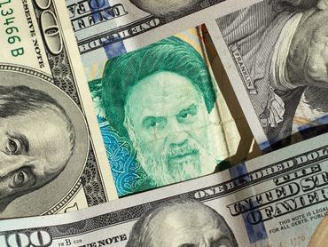 American dollars and Iranian rials background.