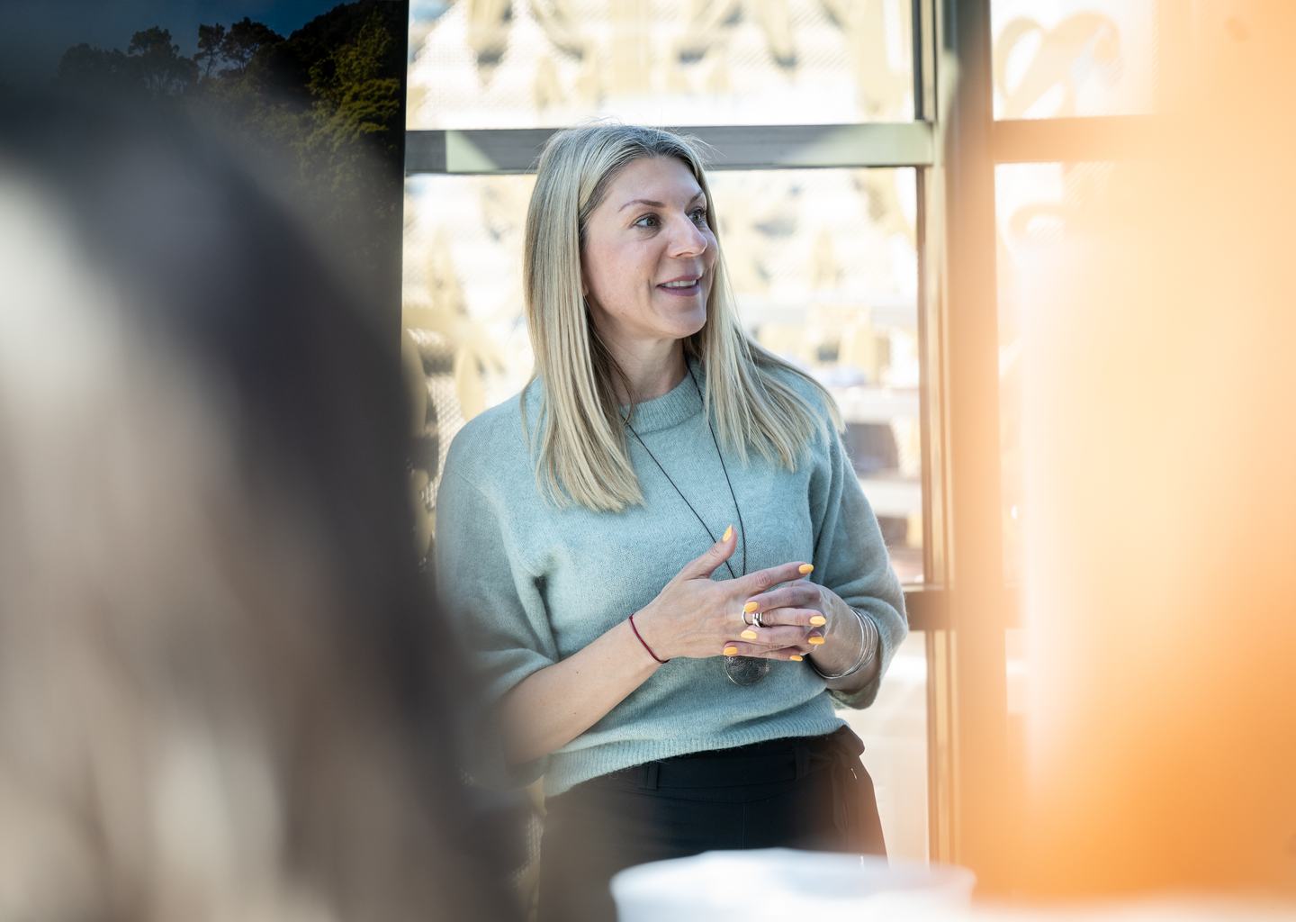 Ivana Herceg sajtótájékoztatón beszél egy napsütötte kávézóban