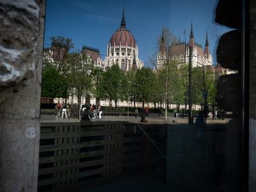 A parlament épülete tükröződik egy kirakatban a Kossuth téren