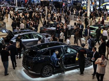 BEIJING, CHINA - APRIL 24: People look at electric vehicles made by Zeekr, a division of Chinese automaker Geely, are displayed on media day at the Beijing International Auto Exhibition on April 24, 2026 in Beijing, China. The biennial showcase, held at the China International Exhibition Center, brings together leading global and domestic automakers to unveil their latest models, concept vehicles, and electric mobility innovations for the world's largest automotive market. (Photo by Kevin Frayer/Getty Images)