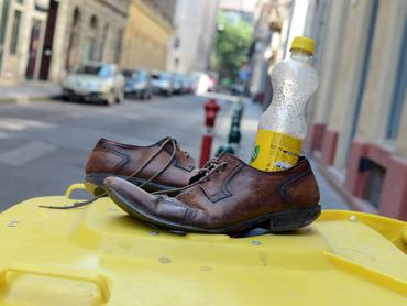 Old leather shoes and an empty bottle stand on a yellow rubbish can in Budapest, Hungary, 06 August 2013. Photo: Jens Kalaene | usage worldwide   (Photo by Jens Kalaene/picture alliance via Getty Images)