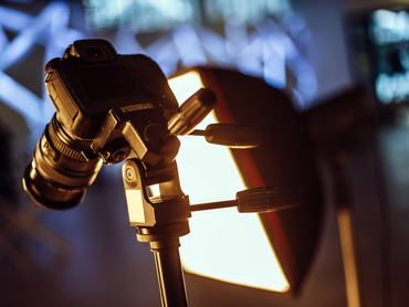 Fényképezőgép állványon és egy lámpa egy stúdióban