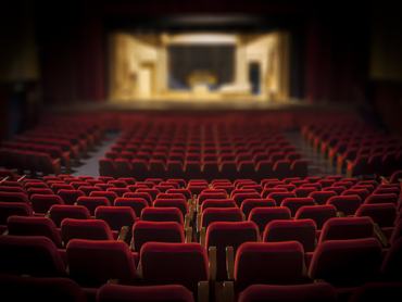 Empty red armchairs of a theater ready for a show