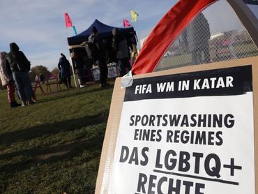 BERLIN, GERMANY - NOVEMBER 19: People gather in front of the Reichstag to protest against the 2022 FIFA World Cup, which is scheduled to begin tomorrow in Qatar, on November 19, 2022 in Berlin, Germany. The protest, organized by the activists group Extinction Rebellion, is calling Qatar out for what it says is egregious human rights abuses and greenwashing throughout the construction of the new football stadiums ahead of the World Cup.  (Photo by Sean Gallup/Getty Images)