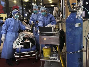 SHANGHAI, CHINA - JANUARY 14: (CHINA AND HONG KONG-OUT) Medical staff triage a patient after being brought by ambulance at the entrance of a busy hospital on January 14, 2023 in Shanghai, China.Chinas health care system has been struggling to cope with a surge of COVID-19 infections since the government ended nearly three years of tough zero COVID controls. At least 900 million people have been infected, according to a Peking University study, and authorities have reported 60,000 COVID-related deaths in hospitals alone in the past month. Infections have peaked in major cities including Beijing and Shanghai, but a second wave is expected to hit in rural areas with hundreds of millions of people traveling to their hometowns during the Lunar New Year holiday. Health officials are concerned that rural populations tend to be older, and the medical system in smaller towns and villages are not as well-resourced as bigger cities. (Photo by Kevin Frayer/Getty Images)