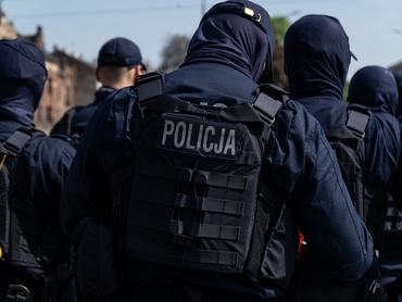 Lengyel rohamrendőrök állnak háttal egy csoportban