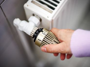28 December 2023, Lower Saxony, Norden: A woman sets the temperature of a radiator on a thermostat. Photo: Matthias Balk/dpa (Photo by Matthias Balk/picture alliance via Getty Images)