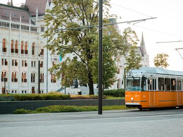 Yellow tram on the  view of the Parliament Hungary, Budapest in sunny day