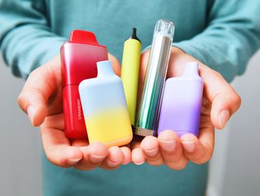 Schoolboy holding vapes in school