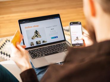 A man browses online to find the perfect pair of brand new shoes