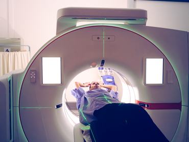 A young multiracial female is undergoing a diagnostic medical imaging procedure in a state-of-the-art hospital setting with CT simulator. The image illustrates the use of cutting-edge technology for healthcare and treatment in a modern medical environment. The portrayal highlights precision, care, and the sophistication of contemporary medical practices.