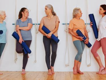 Yoga, conversation and senior women in class, gossip and fitness with feedback, exercise and healthy. People, friends and group in wellness center, body care and community with pilates studio or talk