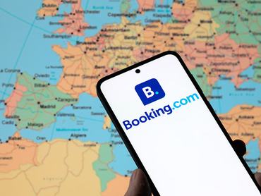 The Booking.com logo is displayed on a mobile phone in this photo illustration in Brussels, Belgium, on August 4, 2025. (Photo by Jonathan Raa/NurPhoto via Getty Images)