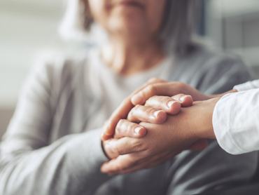 Hands holding old woman's hands