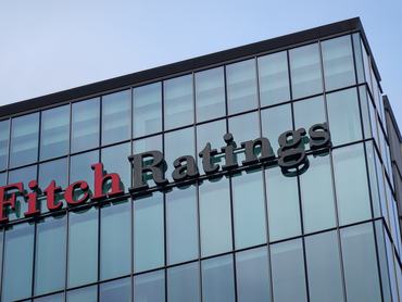The logo of Fitch Ratings is on the rooftop of its UK headquarters in the Canary Wharf financial district in London, England, United Kingdom, on December 26, 2025. Fitch Ratings is one of the ''Big Three'' credit rating agencies globally and provides independent credit research and analytical data for financial markets. (Photo by Michael Nguyen/NurPhoto via Getty Images)