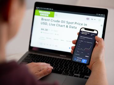 A woman compares websites with Brent crude oil price charts on her phone and computer in Krakow, Poland, on March 3, 2026. Global oil prices surge following military strikes by the United States and Israel against Iran. The price rise is the financial market's reaction to the Middle East conflict and the escalating global energy crisis. (Photo by Marcin Golba/NurPhoto via Getty Images)