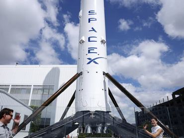 HAWTHORNE, CALIFORNIA - APRIL 02: People walk past a SpaceX Falcon 9 rocket displayed at a SpaceX facility on April 2, 2026 in Hawthorne, California. Elon Musk’s rocket and satellite company SpaceX has confidentially filed for an initial public offering (IPO) in what may be one of the largest public offerings in history. (Photo by Mario Tama/Getty Images)