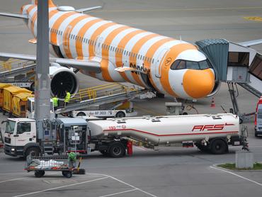 14 April 2026, Bavaria, Munich: A refueling vehicle (front) drives past a passenger boarding bridge in front of a Condor passenger aircraft. The price of kerosene is a key cost factor in air travel and influences ticket prices and airlines' financial results, among other things. Photo: Karl-Josef Hildenbrand/dpa (Photo by Karl-Josef Hildenbrand/picture alliance via Getty Images)