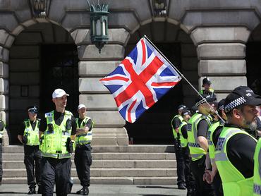 NOTTINGHAM, ENGLAND - MAY 24: A Nationalist supporters waves a Union flag at anti racist protesters the other side of the police lines during the demonstration on May 24, 2026 in Nottingham, England. Left-wing protesters have held a counter protest to a nationalist gathering in the Old Market Square. Police officers implemented cordons and a sterile area to keep opposing protesters apart. (Photo by Martin Pope/Getty Images)