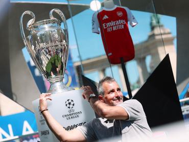 Egy szurkoló pózol a Bajnokok Ligája trófeájával a budapesti Hősök terén 2026. május 28-án