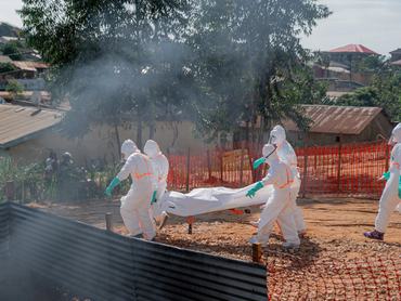 BUNIA, DEMOCRATIC REPUBLIC OF THE CONGO - JUNE 13: A body is taken to the morgue of Nyankunde Medical Center for burial procedures by health teams wearing protective suits as part of epidemic control measures, as an infected citizen who has the Ebola virus has died in Bunia, Democratic Republic of the Congo (DRC), on June 13, 2026. (Photo by Stringer/Anadolu via Getty Images)