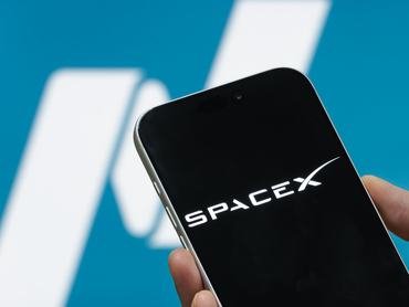 SHENZHEN, CHINA - JUNE 11: In this photo illustration, a smartphone displaying the SpaceX logo is seen in front of a blurred Nasdaq logo on June 11, 2026, in Shenzhen, Guangdong Province, China. SpaceX is preparing for its highly anticipated Nasdaq debut, with the company reportedly seeking a valuation of approximately $1.75 trillion in what could become one of the largest initial public offerings in history. (Photo illustration by Cheng Xin/Getty Images)