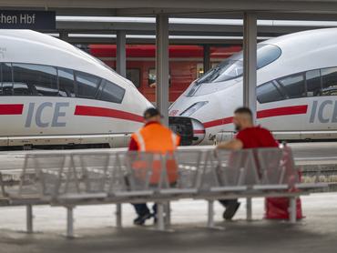 24 June 2026, Bavaria, Munich: Two men are sitting in front of an ICE train at Munich Central Station this morning, following the nationwide service disruption at Deutsche Bahn. According to the company, the disruption has been resolved. Train service is resuming, but there will be subsequent delays and last-minute cancellations. Photo: Peter Kneffel/dpa (Photo by Peter Kneffel/picture alliance via Getty Images)