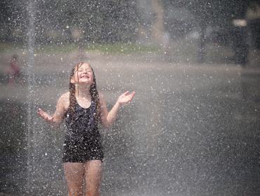 BRADFORD, UNITED KINGDOM.- JUNE 24. Children cool off in the fountains of City Park on June 24, 2026 in Bradford, United Kingdom. The Met Office has upgraded an extreme heat warning to red for six regions of England and Wales on Wednesday and Thursday this week, with amber warnings in effect since Monday. Temperatures are forecast to rise above 30C for several consecutive days, posing intense heat risks for vulnerable people and infrastructure. (Photo by Christopher Furlong/Getty Images)