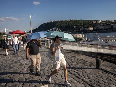BUDAPEST, HUNGARY - JUNE 23: Tourists walk with umbrellas near the Danube on June 23, 2026 in Budapest, Hungary. Various European governments issued health warnings this week in relation to the high temperatures, which were nearing 40 degrees celsius in many large cities. (Photo by Janos Kummer/Getty Images)