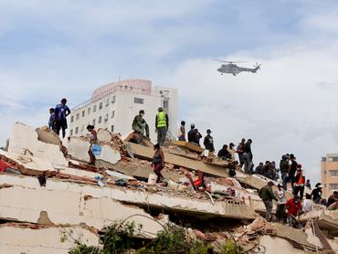 CARABELLADA, VENEZUELA - JUNE 28: Rescuers search for victims at a collapsed building as a helicopter flies by in the background following a magnitude 7.2 earthquake that struck Venezuela and other regions in the Caribbean, on June 28, 2026 in Carabellada, La Guaira, Venezuela. According to the U.S. Geological Survey (USGS), the main earthquake on June 24, 2026 was followed by a 7.5-magnitude aftershock less than a minute later. The number of fatal victims increased to more than 1000, while the number of injured people exceeded 3,000. More than 70,000 people are reported missing. (Photo by Jesus Vargas/Getty Images)