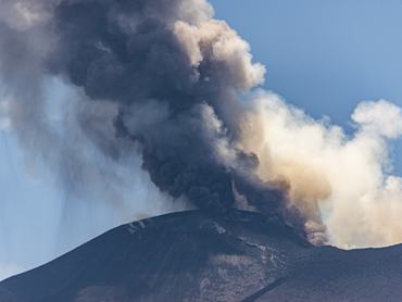 CATANIA, ITALY - JULY 5: A towering ash plume rises from Mount Etna following the resumption of eruptive activity from a vent located on the upper eastern flank of the Voragine summit crater as the Volcano Observatory Notice for Aviation (VONA) remains at RED alert level in Catania, Sicily, Italy, on July 5, 2026. The ash emission generated an eruption column reaching approximately 1.5 kilometres above the volcano's summit, drifting toward the south and south-southeast. The effusive lava flow, which had been active since June 26, ceased on July 4, while Strombolian activity continues at the summit vent. The presence of volcanic ash prompted temporary airspace restrictions south of the volcano, affecting operations at Catania Airport. (Photo by Salvatore Allegra/Anadolu via Getty Images)