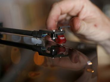 Story is a profile on three new vinylonly record stores openign next nonth in Los Angeles, and a longview look at the economic viablity of vinyl as a format for labels and retailers to be investing in. Origami is the project from Neil Schield, a record label owner and former digitalmusic distribution worker trying his hand at a lifelong dream of owning a vinyl store to stock his favorite indie rock, rap and pop records. Neil Schield places teh needle on the record for a little music at his W. Sunset Blvd. location in Echo Park.  (Photo by Kirk McKoy/Los Angeles Times via Getty Images)