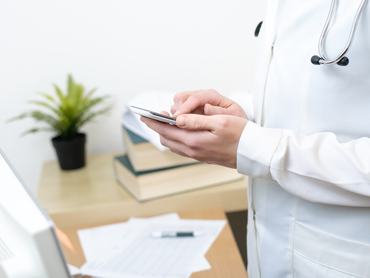A female doctor texting on smartphone in medical office