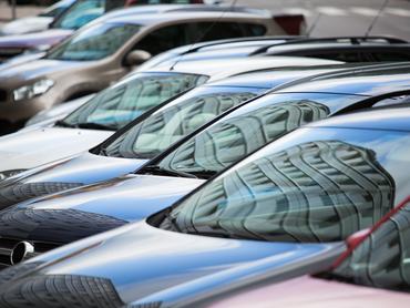 Autók parkolnak egymás mellett egy utcán