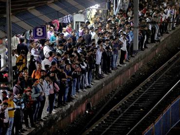 FILE PHOTO: Commuters crowd on a platform as they wait to board suburban trains at a railway station in Mumbai, India, January 20, 2023. REUTERS/Niharika Kulkarni/File Photo