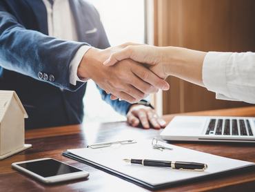 Real estate agent and customers shaking hands together celebrating finished contract after about home insurance and investment loan, handshake and successful deal.