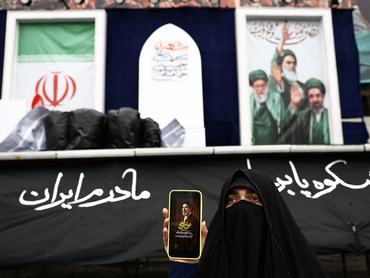 A woman shows a picture of Iran's new Supreme Leader, Mojtaba Khamenei, on her mobile phone in a street, amid the U.S.-Israeli conflict with Iran, in Tehran, Iran, March 26, 2026. Majid Asgaripour/WANA (West Asia News Agency) via REUTERS ATTENTION EDITORS - THIS PICTURE WAS PROVIDED BY A THIRD PARTY