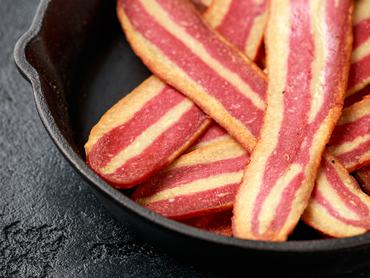 Fried crunchy plant based vegan Bacon pieces in a cast iron skillet.