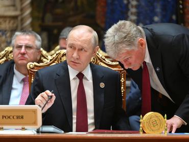 Vlagyimir Putyin orosz elnök és Dmitrij Peszkov, a Kreml szóvivője a FÁK dusanbei csúcstalálkozóján 2025. október 10-én.
