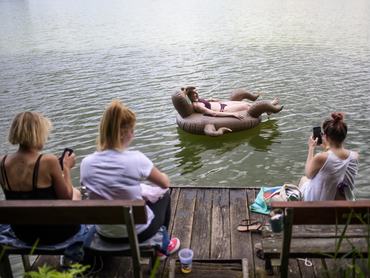 Felfújható matracon pihen egy fiatal nő a Bánki-tóban a Bánkitó Fesztiválon a Nógrád megyei Bánkon 2019. július 11-én