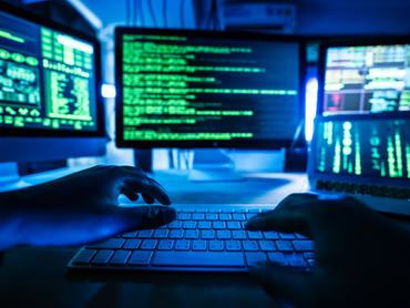 A view of a programmer working on multiple screens, showcasing coding and technology in action.