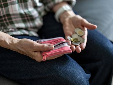 Close-up of an elderly woman’s hands holding a coins
