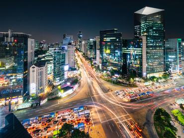 Seoul South Korea. Aerial Panorama of famous crowded city street crossing at downtown Gangnam Station at Night with motion blured traffic lights and surrounding modern illuminated skyscrapers. Gangnam District, Seoul, South Korea, Southeast Asia
