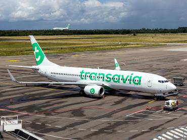 Transavia Boeing 737 passenger planes at the terminal and landing at Eindhoven Airport. The Netherlands - July 6, 2020